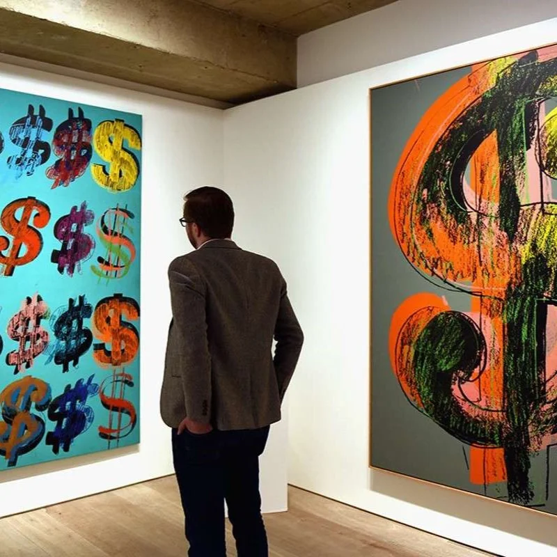 Man Looking At A PIece Made Out Of Dollar Signs 300x300